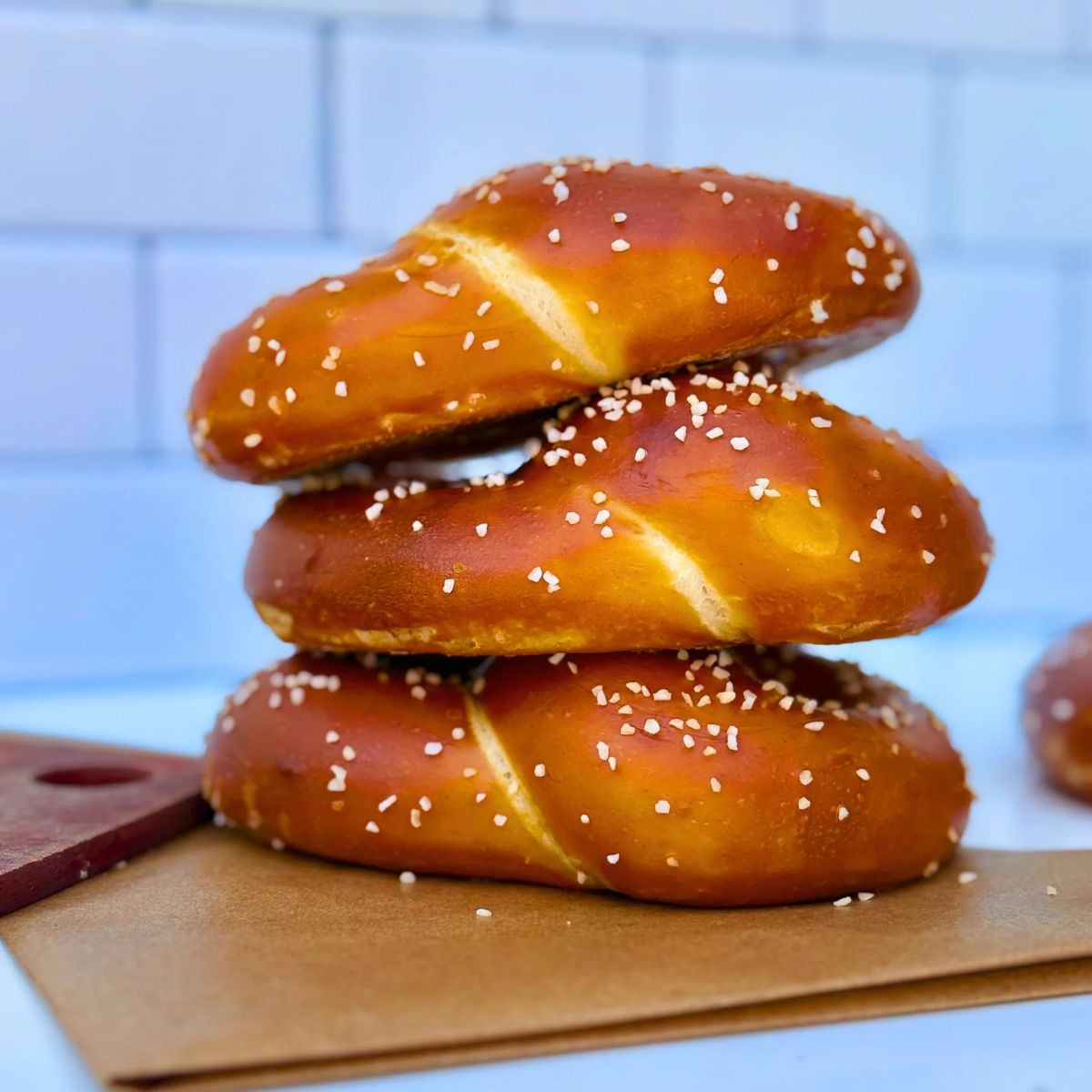 Three pretzels stacked on top of each other with a blue tiled background