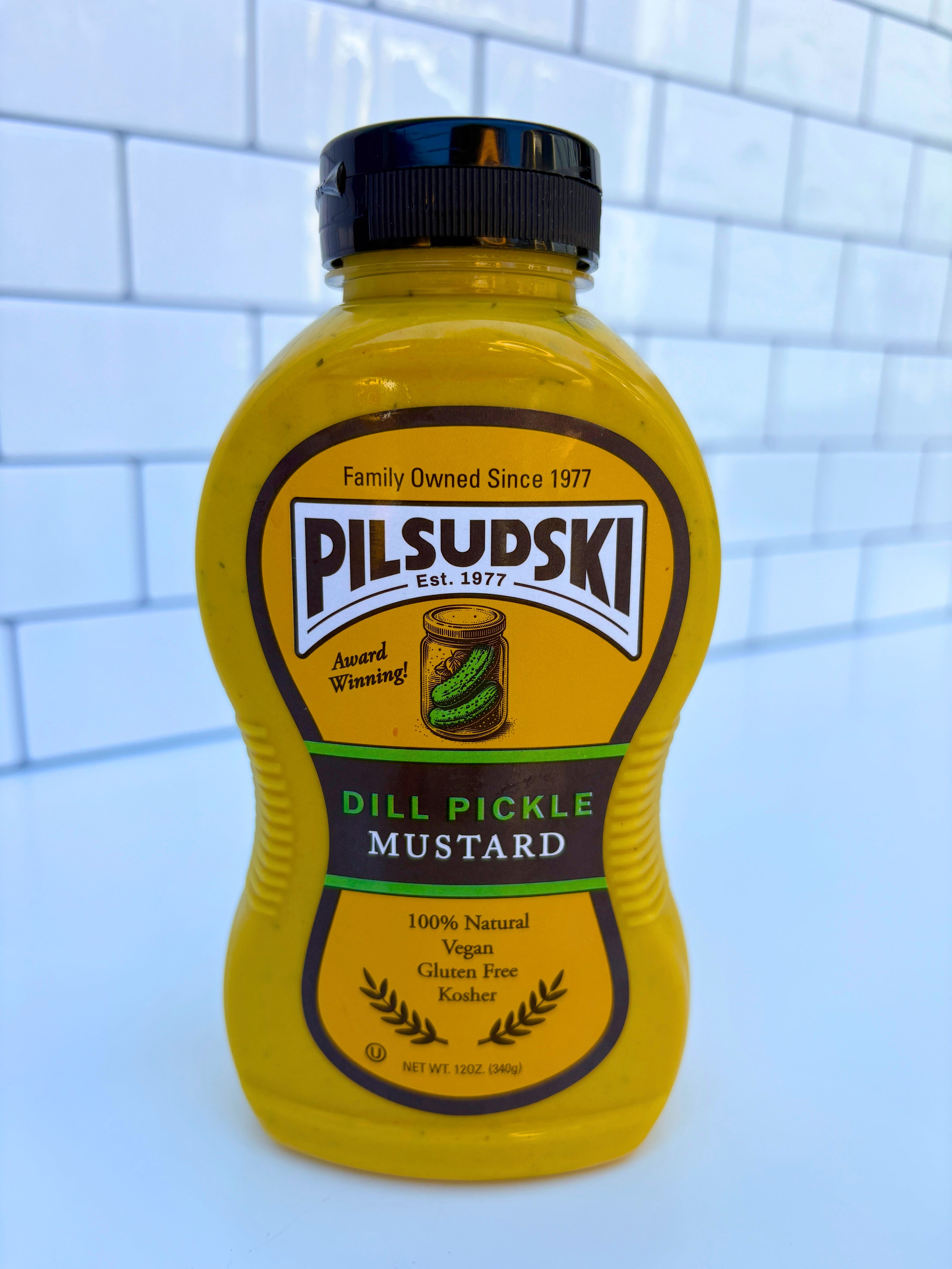 Bottle of Pilsudski Dill Pickle Mustard on a tiled wall background